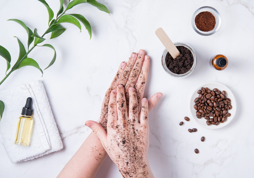 spa-concept-young-woman-does-hand-massage-with-homemade-coffee-scrub-from-recycle-capsule-with-olive-oil-marble-background-top-view